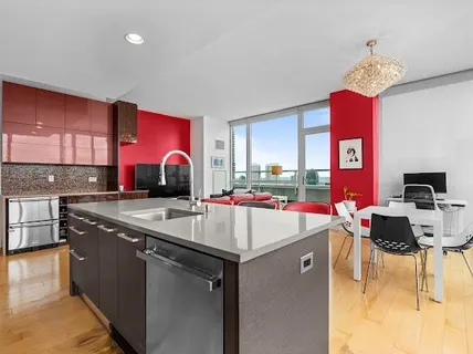 a kitchen with stainless steel appliances granite countertop a sink dishwasher and a stove with wooden cabinets
