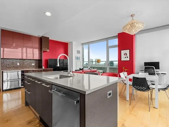 a kitchen with stainless steel appliances granite countertop a sink dishwasher and a stove with wooden cabinets