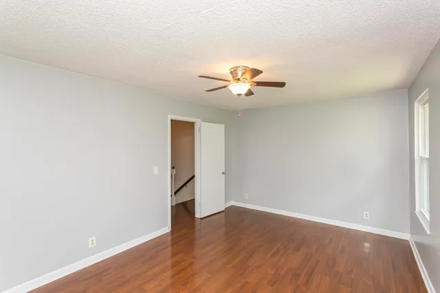 an empty room with a window and wooden floor