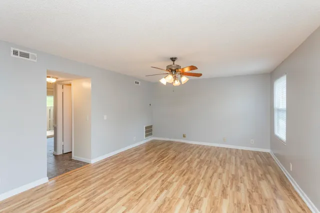 a view of empty room with wooden floor