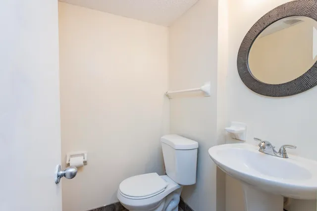 a white toilet sitting next to a bathroom sink