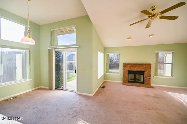a view of an empty room with a fireplace and a window