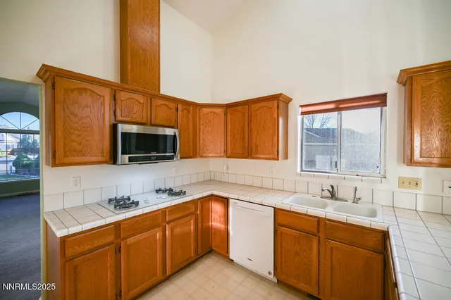 a kitchen with stainless steel appliances granite countertop a sink stove and microwave