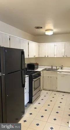 a kitchen with a refrigerator stove and white cabinets