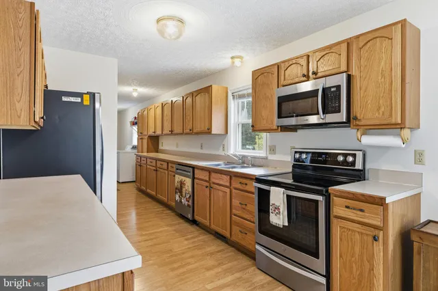 a kitchen with stainless steel appliances granite countertop a stove microwave and sink