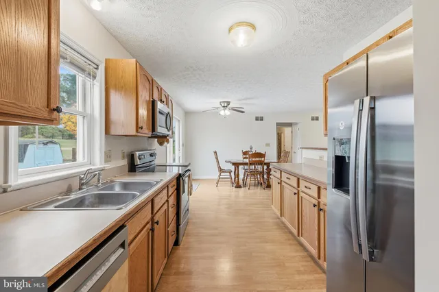 a kitchen with stainless steel appliances granite countertop a sink refrigerator and cabinets