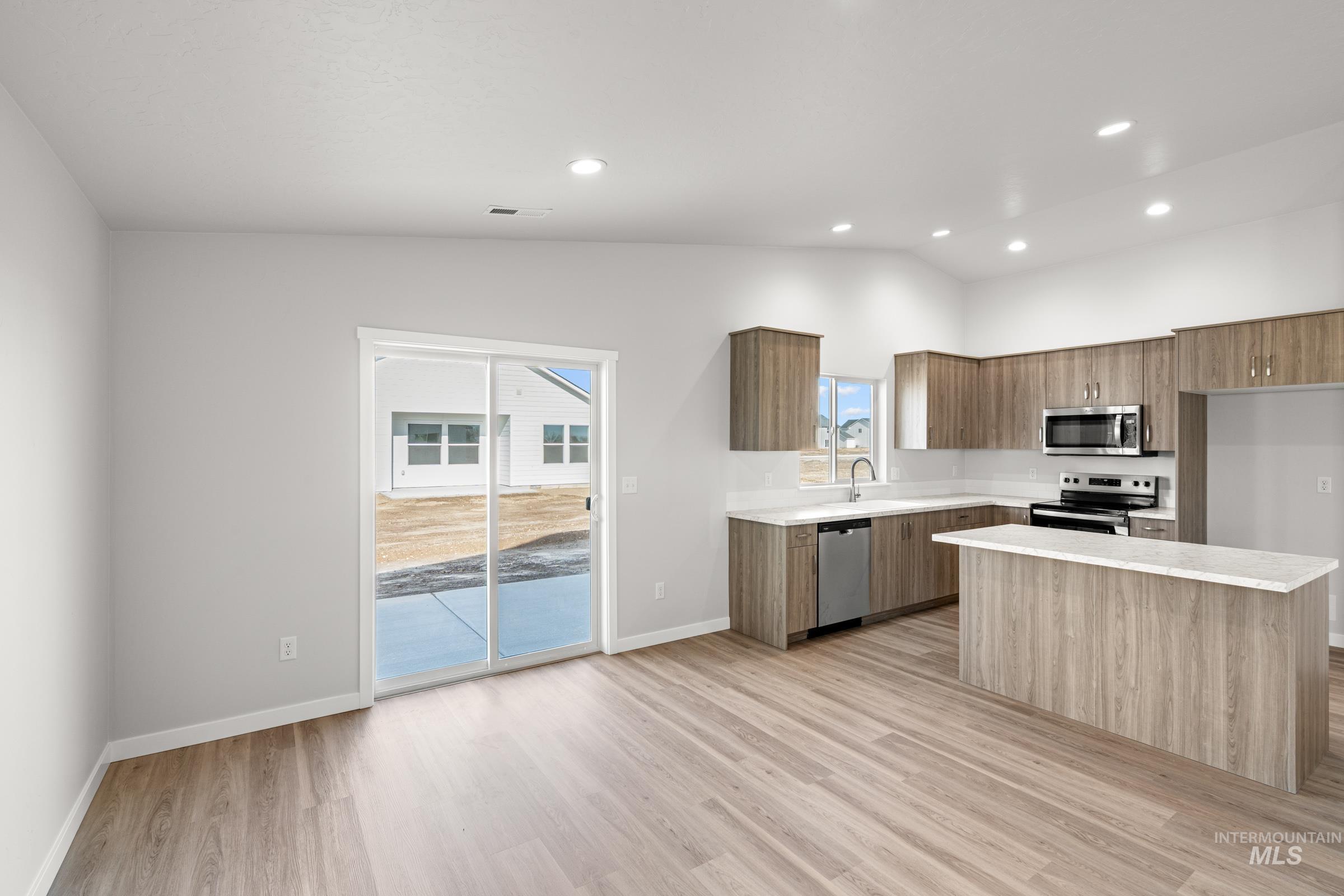 1622 Covington Street Middleton, ID 83644 - Photo 3 of 19 Kitchen featuring modern cabinets, stainless steel appliances, a kitchen island, light wood-type flooring, and lofted ceiling