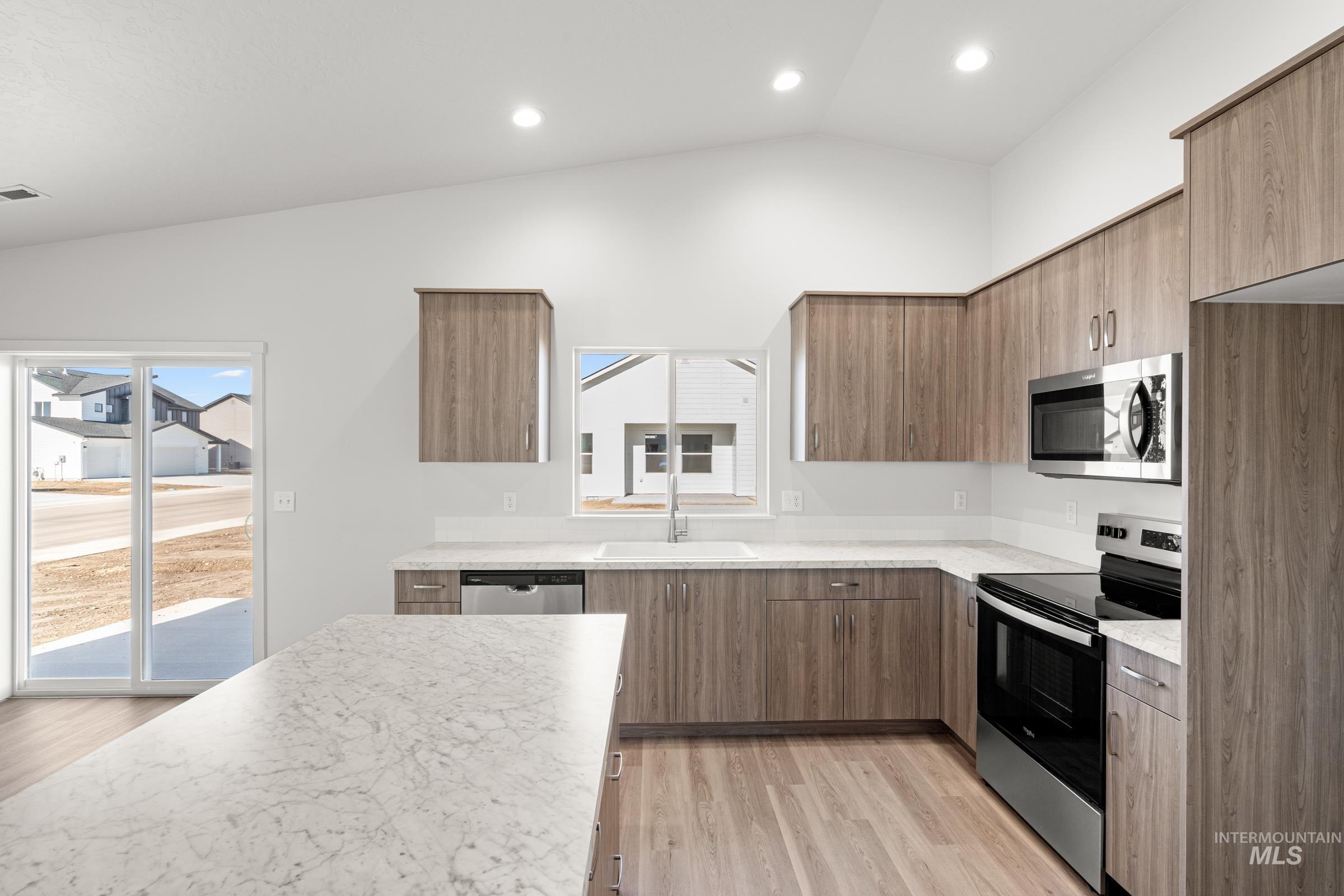 1622 Covington Street Middleton, ID 83644 - Photo 5 of 19 Kitchen with stainless steel appliances, lofted ceiling, light wood-style floors, modern cabinets, and recessed lighting
