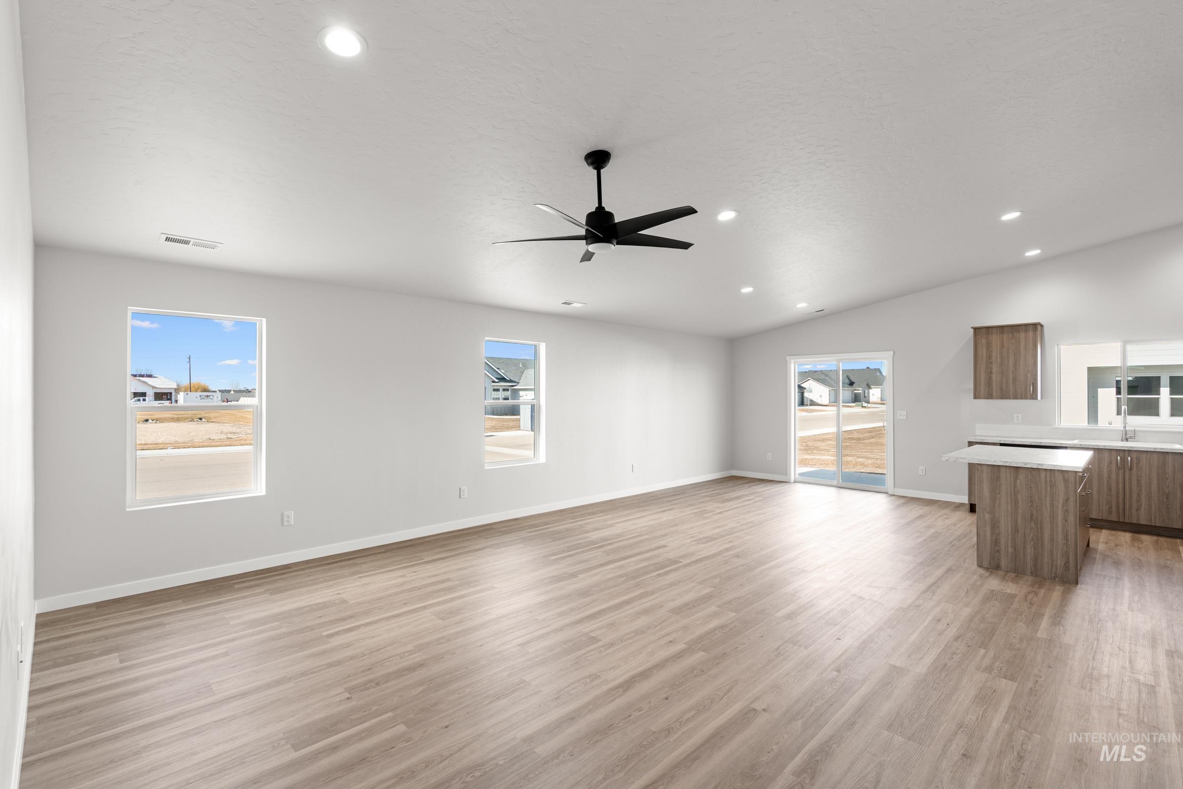 1622 Covington Street Middleton, ID 83644 - Photo 7 of 19 Unfurnished living room with light wood-type flooring, a ceiling fan, lofted ceiling, and recessed lighting