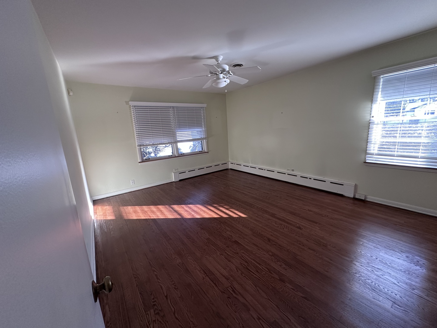 2300 Landwehr Road Northbrook, IL 60062 - Photo 21 of 28 an empty room with wooden floor chandelier fan and windows