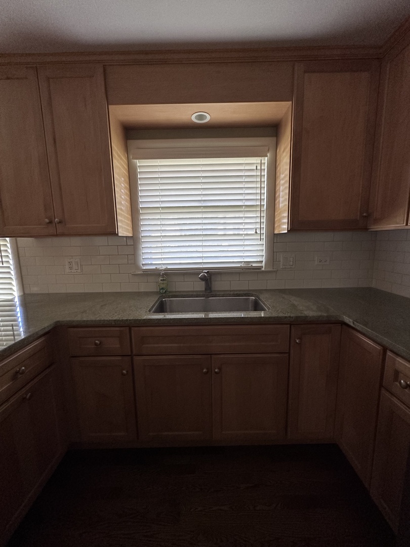 2300 Landwehr Road Northbrook, IL 60062 - Photo 7 of 28 a kitchen with granite countertop sink cabinets and window