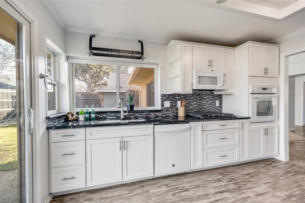 3919 Winter Park Lane Addison, TX 75001 - Photo 11 of 25 Kitchen featuring white cabinets, crown molding, white appliances, open shelves, and dark stone countertops