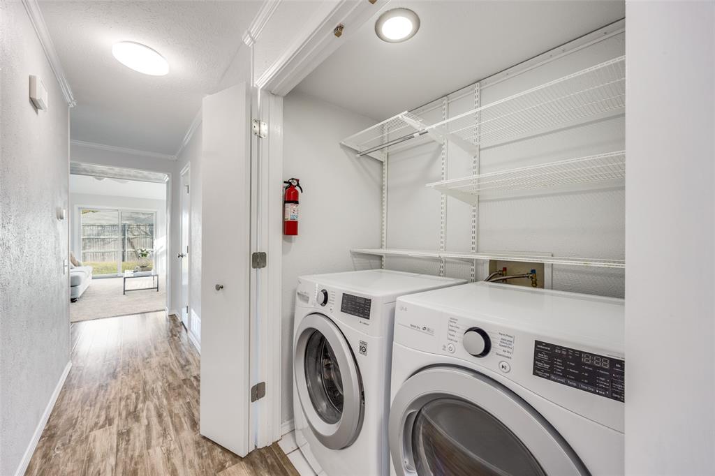 3919 Winter Park Lane Addison, TX 75001 - Photo 13 of 25 Laundry area with crown molding, washing machine and clothes dryer, light wood-style floors, and a textured ceiling