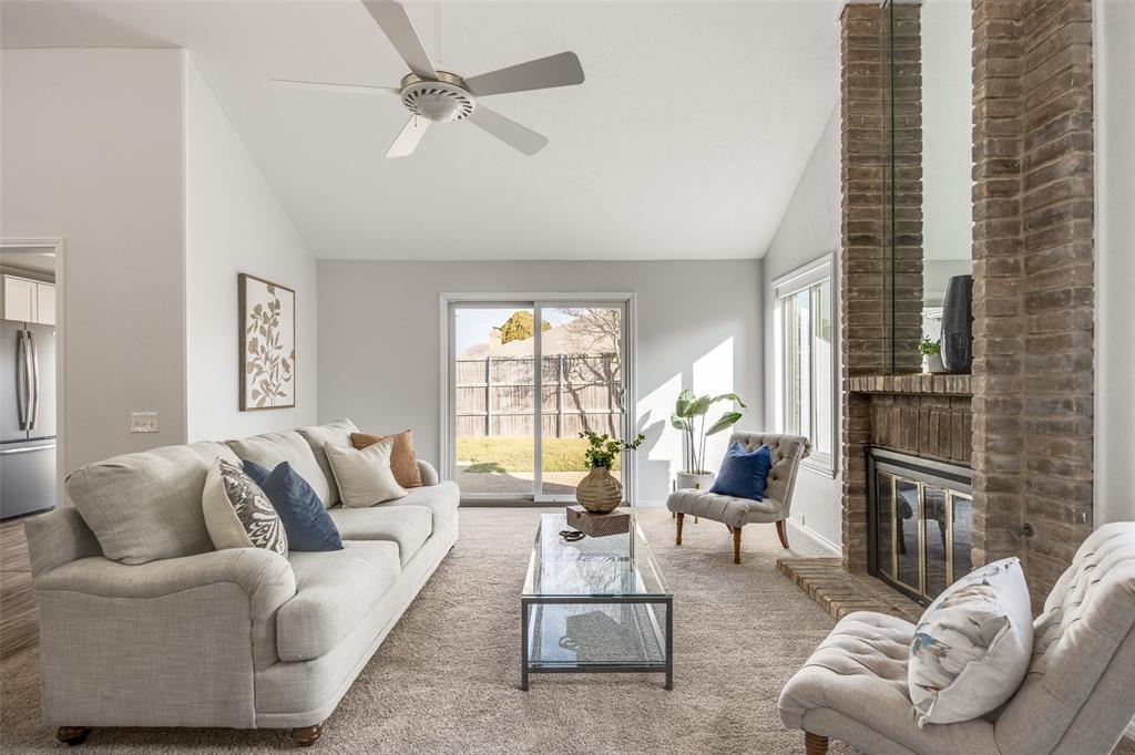 3919 Winter Park Lane Addison, TX 75001 - Photo 5 of 25 Living room with lofted ceiling, ceiling fan, carpet floors, and a brick fireplace