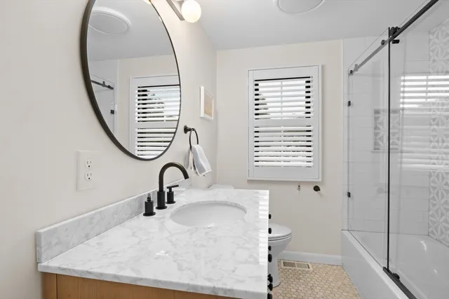 a bathroom with a sink a toilet and a mirror