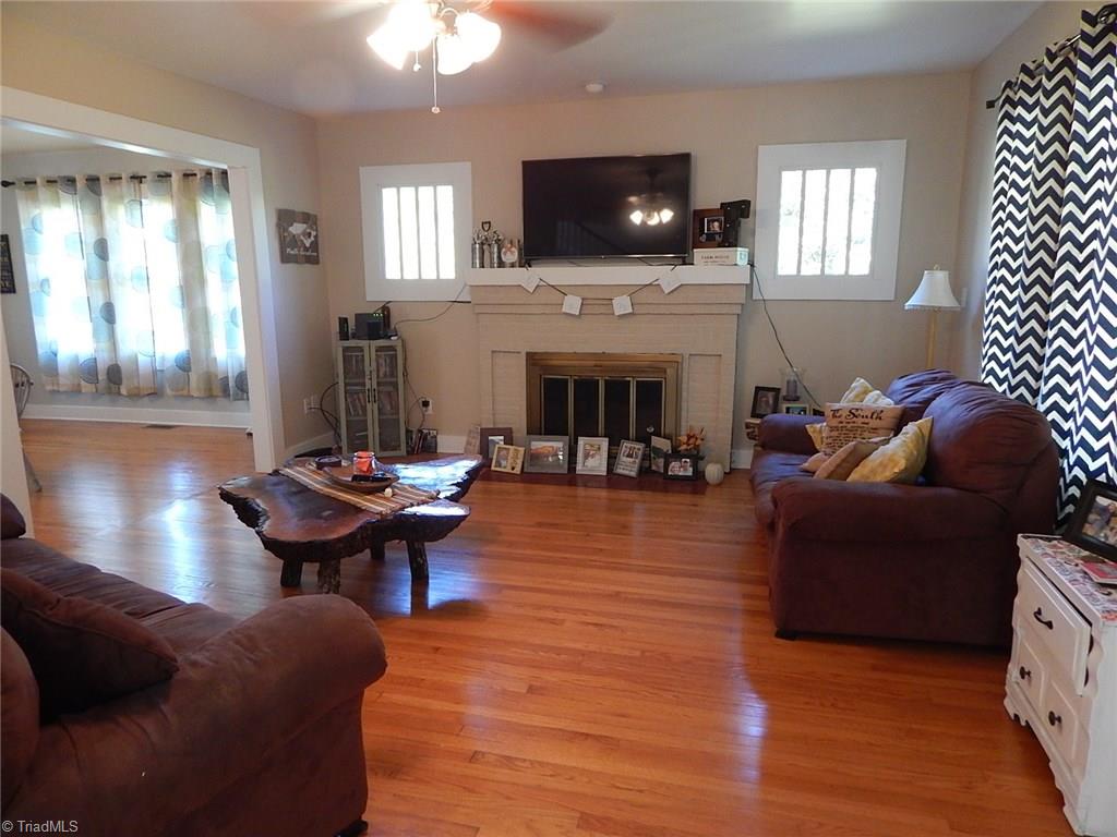 3990 Beasley School Road Sandy Ridge, NC 27046 - Photo 2 of 28 Spacious living room with wood flooring, ceiling fan, and fireplace!