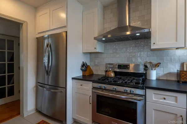 a kitchen with stainless steel appliances granite countertop a stove a refrigerator and a cabinets