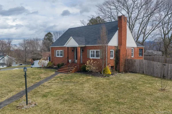 a view of a house with a yard and large tree