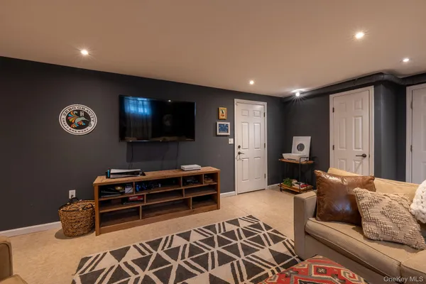 a living room with furniture a flat screen tv and a window