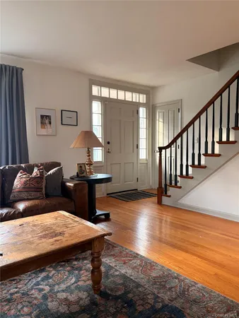 a living room with furniture a large window and a wooden floor
