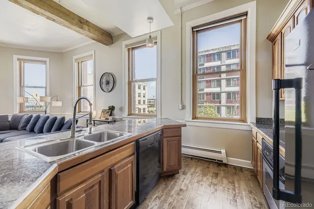 a kitchen with a stove a refrigerator and a dining table with wooden floor