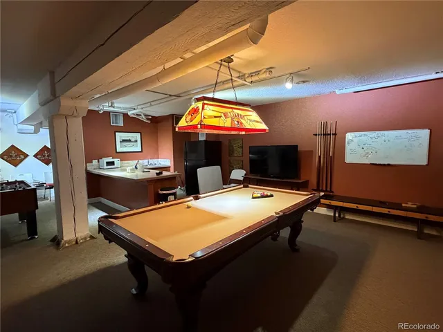 a room with table chairs and a flat screen tv