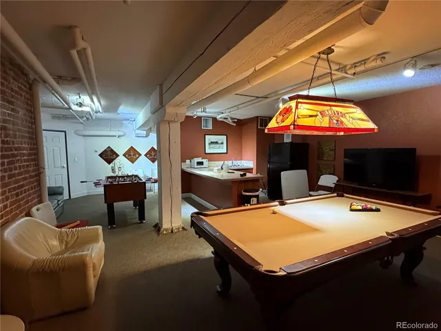 a room with furniture pool table and flat screen tv