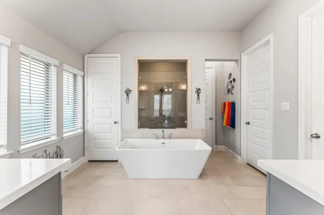a bathroom with a tub sink and mirror