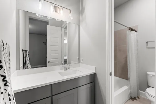 a bathroom with a sink vanity and a shower