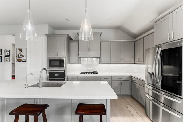 a large kitchen with lots of counter space a sink appliances and a dining table
