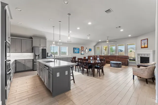 a living room with furniture a window and a dining table with wooden floor