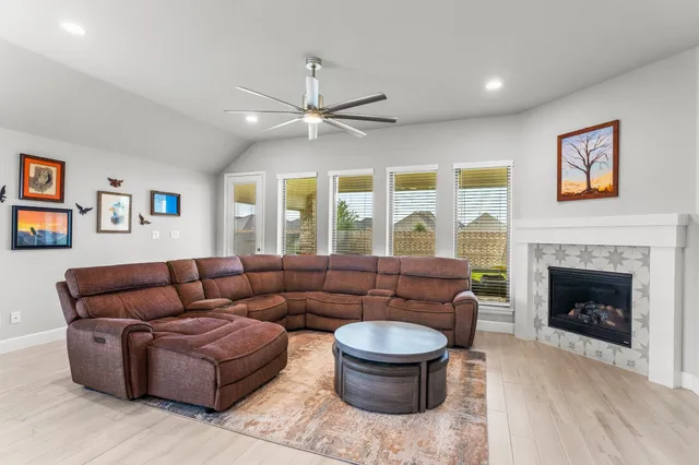 a living room with furniture fireplace and a large window