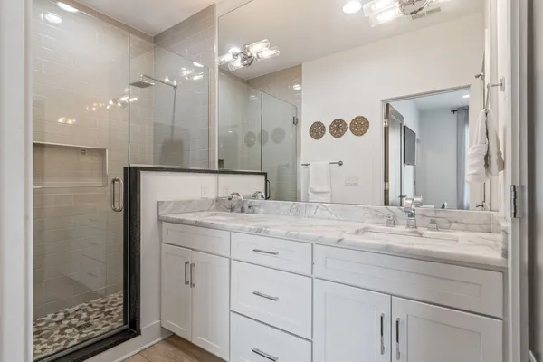 a bathroom with a granite countertop sink mirror and shower