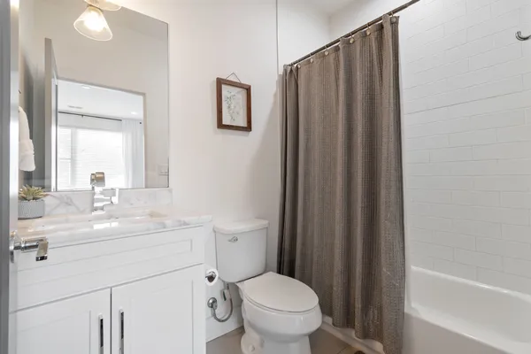 a bathroom with a sink a toilet a mirror and shower