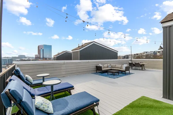 a roof deck with table and chairs a barbeque with potted plants