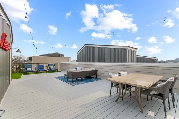 a roof deck with table and chairs