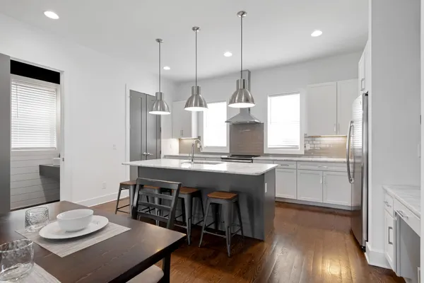 a kitchen with granite countertop a table chairs stove a sink and living room view