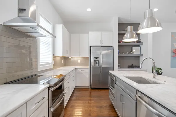 a kitchen with granite countertop a sink stainless steel appliances and cabinets