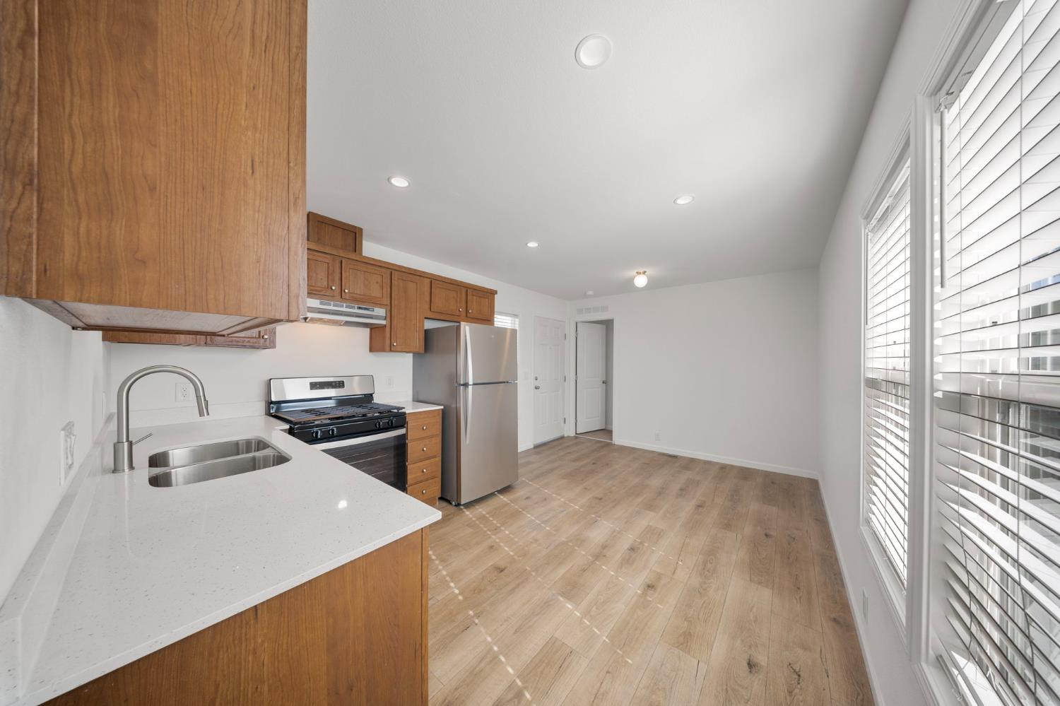 360 East Grant Line Road, Unit 19A Tracy, CA 95376 - Photo 13 of 19 a kitchen with stainless steel appliances a sink a stove a refrigerator cabinets and a large window