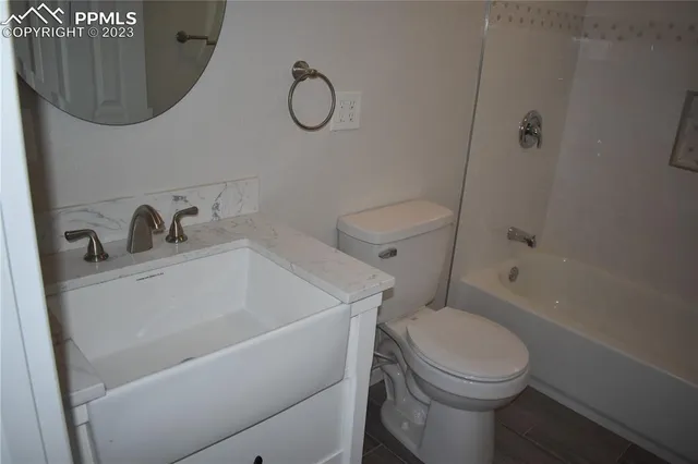 a bathroom with a toilet a sink a mirror and vanity