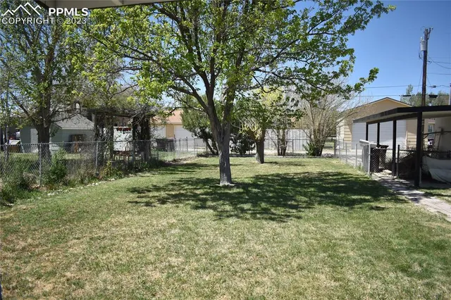 an empty room with wooden floor a ceiling fan and windows