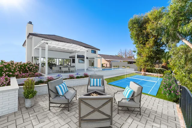 a view of a patio with a dining table and chairs with an umbrella