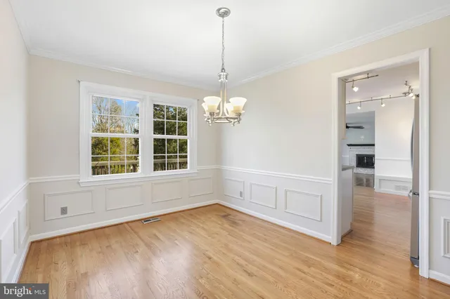a view of an empty room with a window and kitchen view