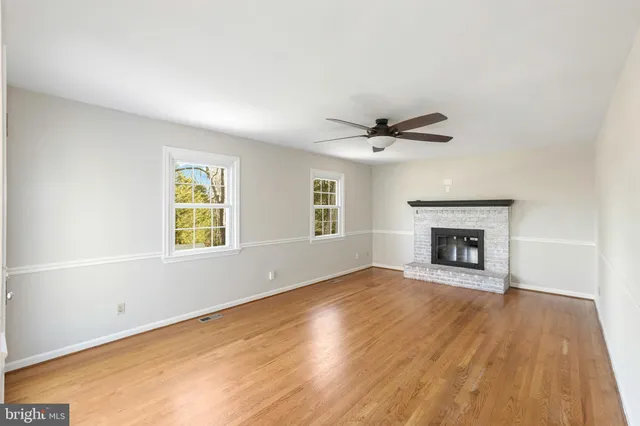 an empty room with windows and fireplace