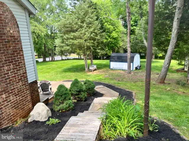 a front view of a house with garden and trees