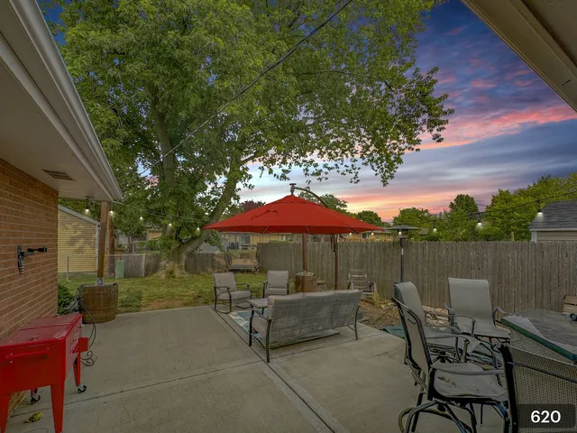 a view of backyard with outdoor seating and trees
