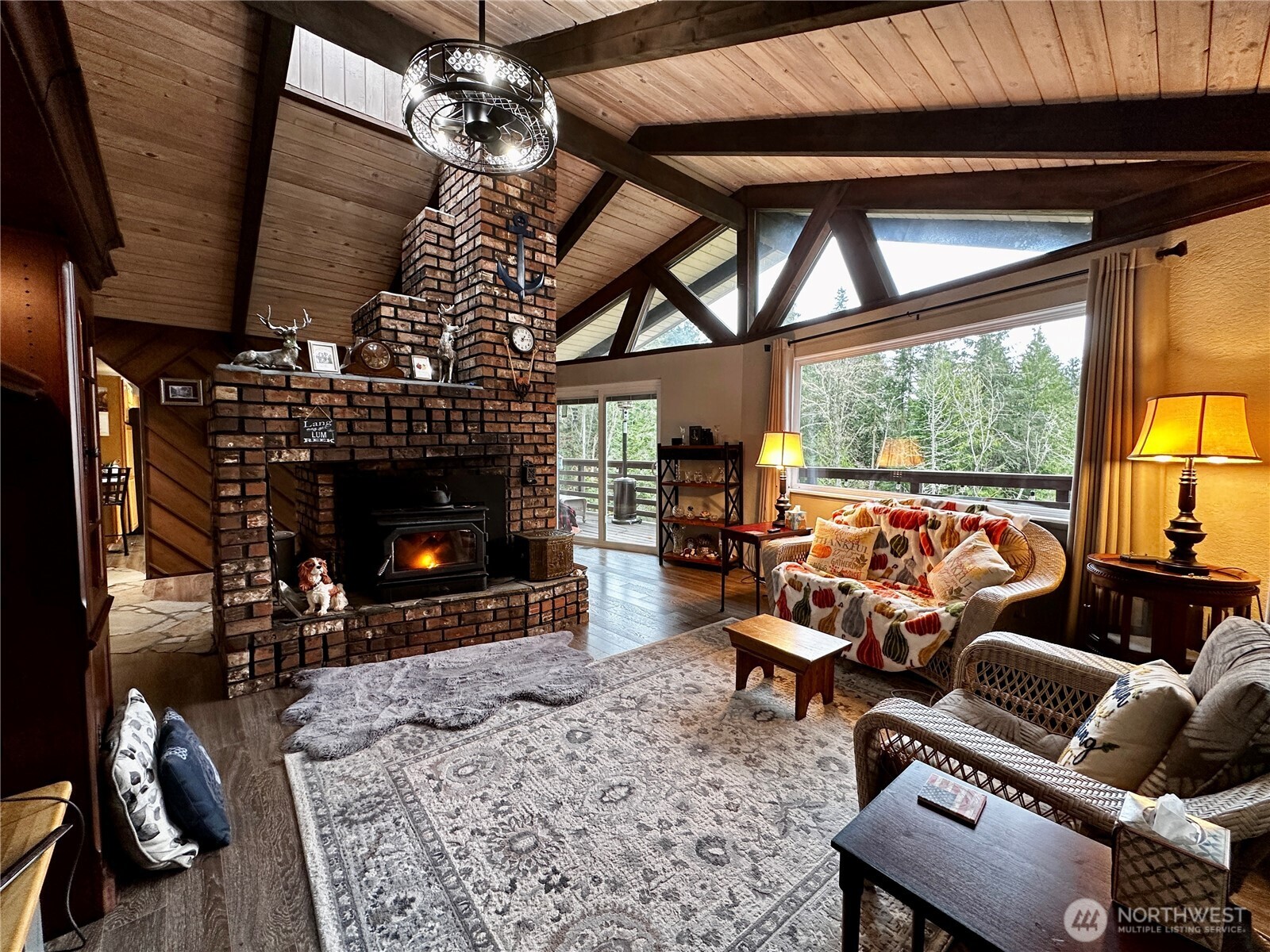 364 Old Dads Road Sequim, WA 98382 - Photo 12 of 37 a living room with furniture a fireplace and a floor to ceiling window