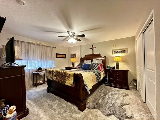 a bedroom with a bed and dresser with mirror