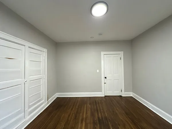 an empty room with wooden floor and window