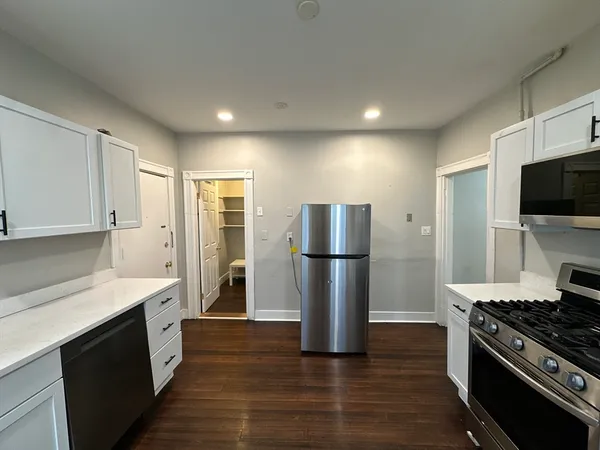 a kitchen with a refrigerator and a stove top oven